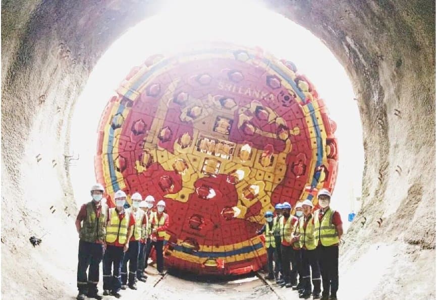 Project crew assembled in front of the double-shield TBM cutterhead inside the tunnel